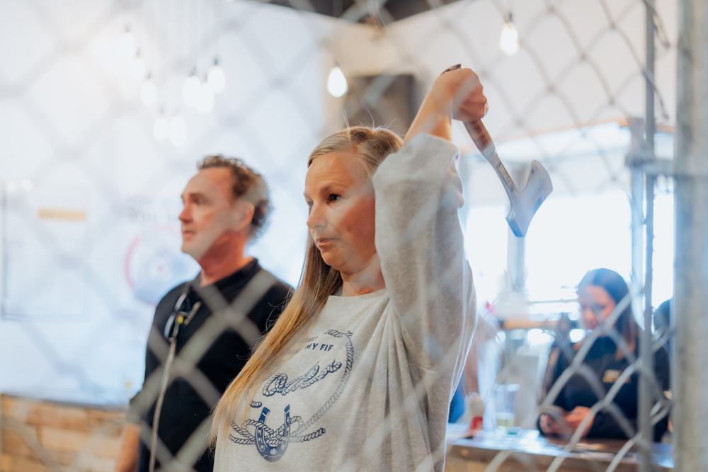 An agent mid-throw at axe throwing