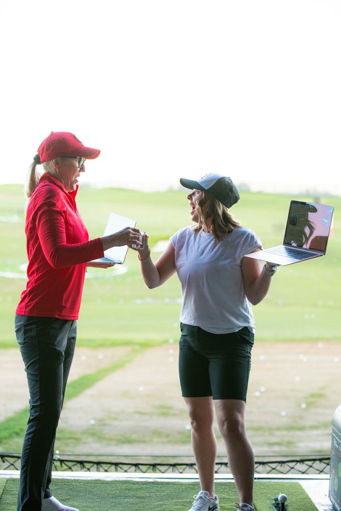 Two agents high-fiving on the driving range